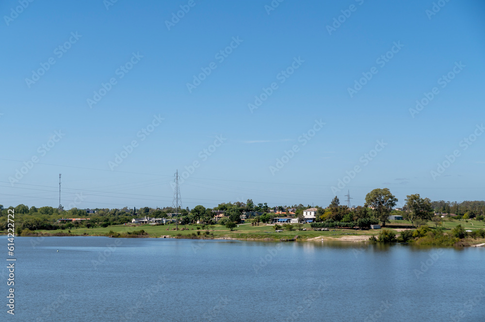 Landscape of a lake and houses in the countryside on a sunny day.