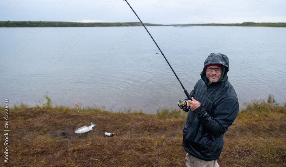 Fisherman catching coho salmon in Egegik river in Alaska. The fish are in abundant supply in Alaskan water. Fisherman catching coho salmon in Egegik river in Alaska. The fish are in abundant supply in Alaskan water.