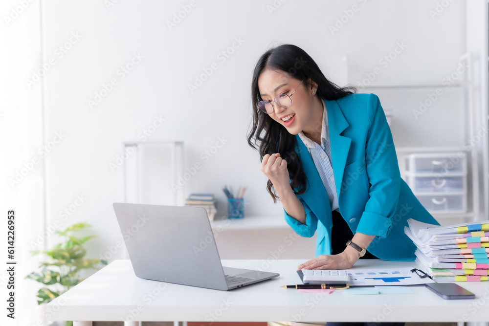 Happy asian businesswoman raising hands with victory smiling happily with laptop computer. The concept of success at work. Happy asian businesswoman raising hands with victory smiling happily with laptop computer. The concept of success at work.
