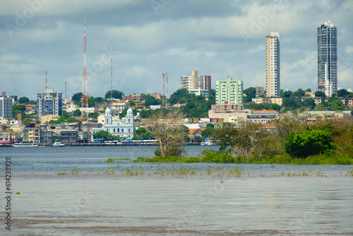 cruising the amazon river view of Santarem city at distance from a boat Brazil