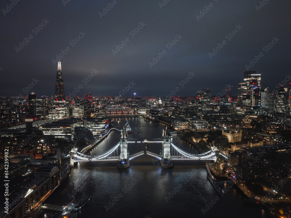 Aerial night view of the lifting up Tower Bridge in London. Beautiful illuminated panorama of London Tower Bridge at night.