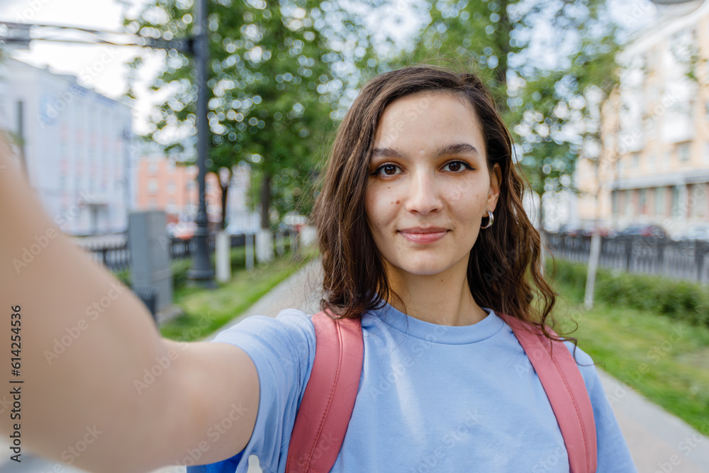 young girl takes a selfie, view from the camera on street young girl takes a selfie, view from the camera on street