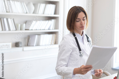Side view on female physician standing and holding documents of patients. Modern health care concept