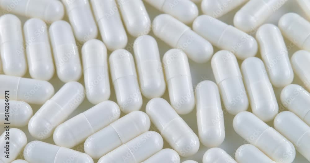 Capsule on a white background filled with medicine is in a chaotic order. Tablets rotate on the table. The dosage form. Therapeutic capsule, tablet. View from above. medical personnel, healthy life Capsule on a white background filled with medicine is in a chaotic order. Tablets rotate on the table. The dosage form. Therapeutic capsule, tablet. View from above. medical personnel, healthy life