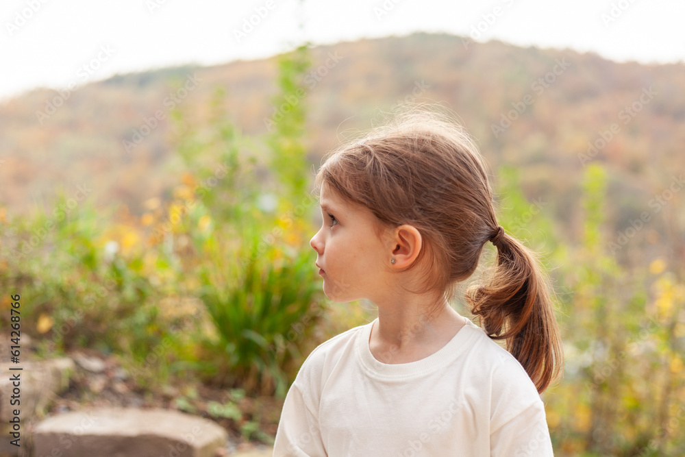 Portrait of a little girl in a white T-shirt on a background of autumn nature Portrait of a little girl in a white T-shirt on a background of autumn nature