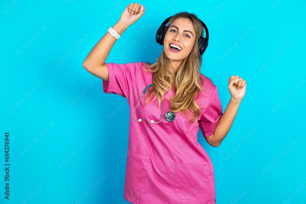 Carefree Young beautiful doctor woman standing over blue studio