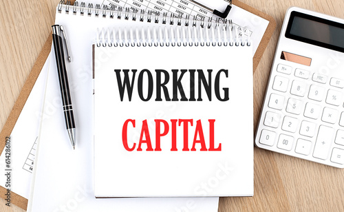 WORKING CAPITAL is written in white notepad near a calculator, clipboard and pen. Business concept