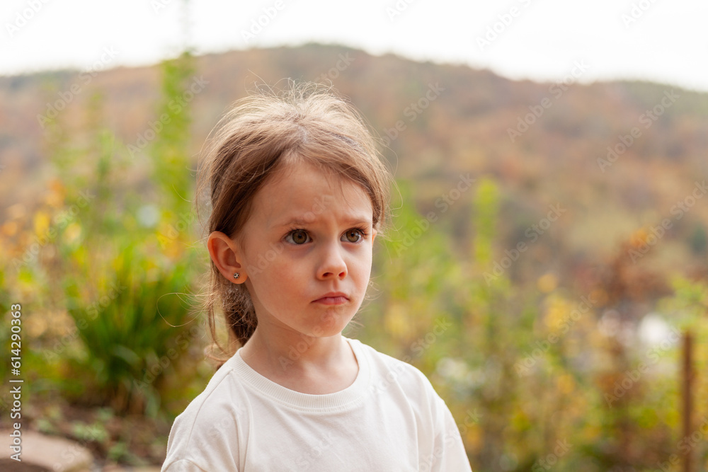 Portrait of a sad little girl in a white T-shirt