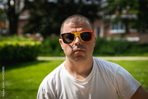 Portrait of a young man in Belgian flag sunglasses.