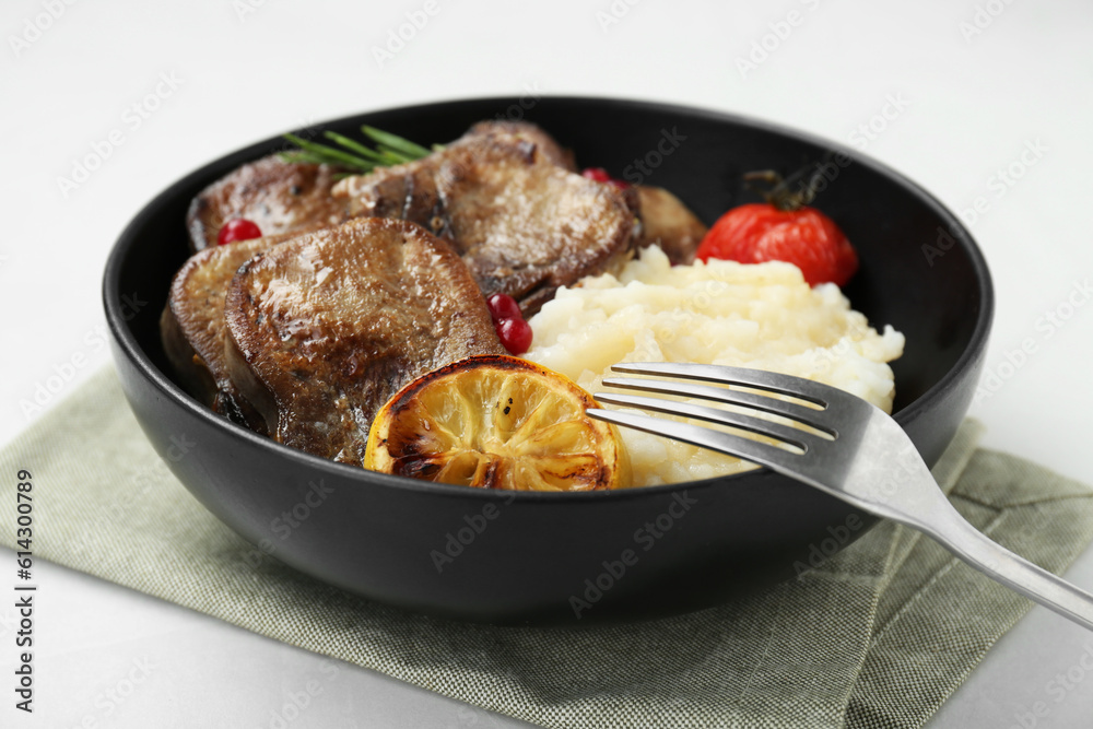 Tasty beef tongue pieces, berries, lemon, rosemary, tomato and mashed potatoes on white table, closeup Tasty beef tongue pieces, berries, lemon, rosemary, tomato and mashed potatoes on white table, closeup