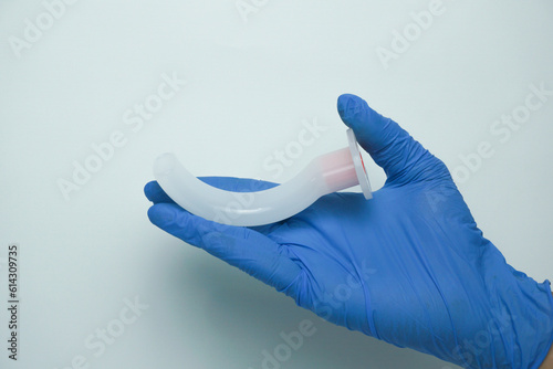 Medical worker wearing medical gloves holding an OPA (Oropharyngeal airway) is a medical device called an airway adjunct that is used in airway management to maintain or open a patient's airway photo