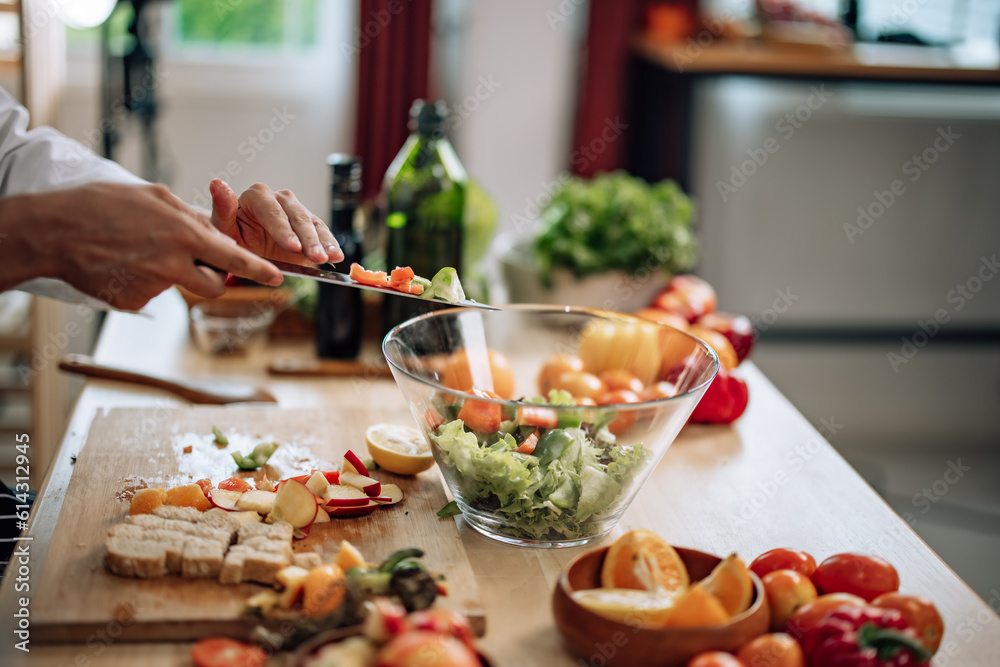 The professional master chef prepares a bowl of various types of fruit and vegetable salad with great passion and enthusiasm. Expertly mix all the ingredients and materials with care and precision. The professional master chef prepares a bowl of various types of fruit and vegetable salad with great passion and enthusiasm. Expertly mix all the ingredients and materials with care and precision.