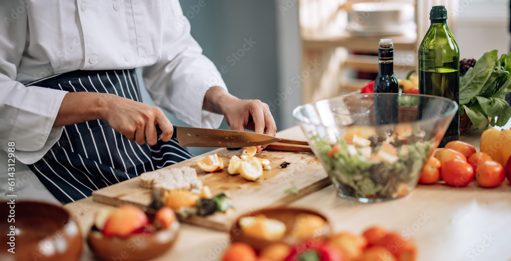 The professional master chef prepares a bowl of various types of fruit and vegetable salad with great passion and enthusiasm. Expertly mix all the ingredients and materials with care and precision.