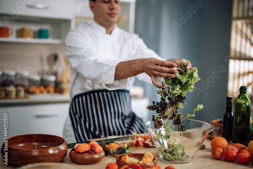 The professional master chef prepares a bowl of various types of fruit and vegetable salad with great passion and enthusiasm. Expertly mix all the ingredients and materials with care and precision.