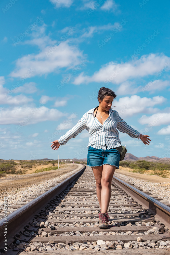 Railway Serenity: Woman Embracing the Desert Breeze on Train Tracks