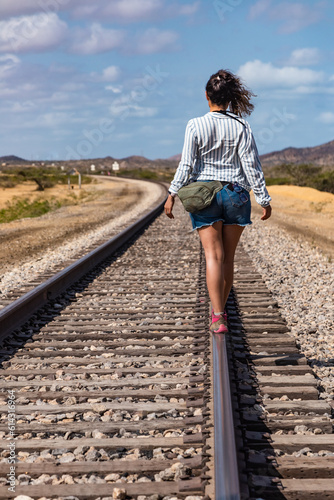 Journey into the Desert: Woman Balancing on Train Tracks