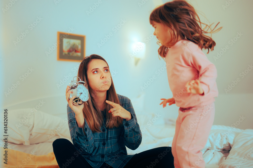 mother-showing-her-hyperactive-daughter-it-is-past-bedtime