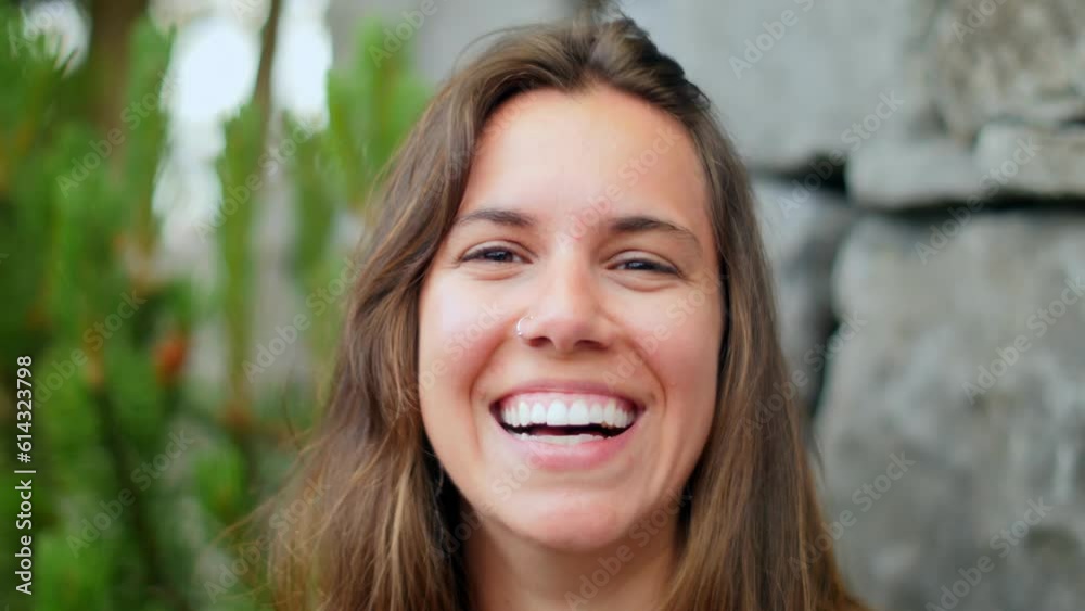 Young woman laughing outdoors, slow motion. Young woman laughing outdoors, slow motion.