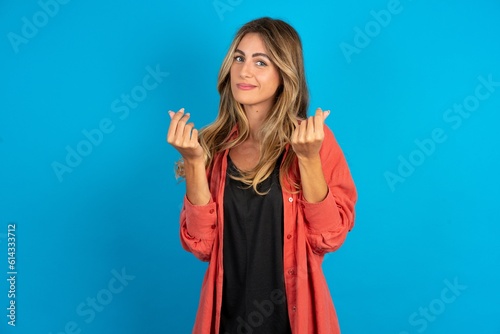 young beautiful blonde woman wearing overshirt doing money gesture with hands, asking for salary payment, millionaire business