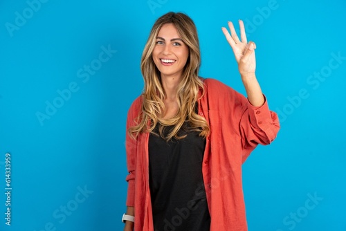 young beautiful blonde woman wearing overshirt showing and pointing up with fingers number three while smiling confident and happy.