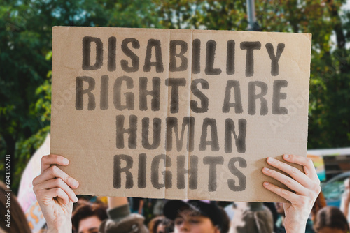 A powerful image of a man’s hand holding a banner with the text ‘Disability rights are human rights.’ Perfect for showcasing support or protest for the rights of people with disabilities worldwide