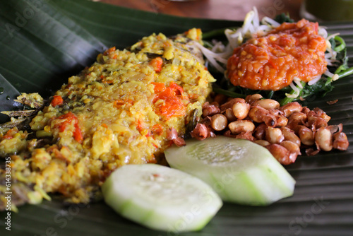Tableau sur toile Traditional balinese food, Mujair Nyat-nyat, served on fresh banana leaf plating with various side dishes
