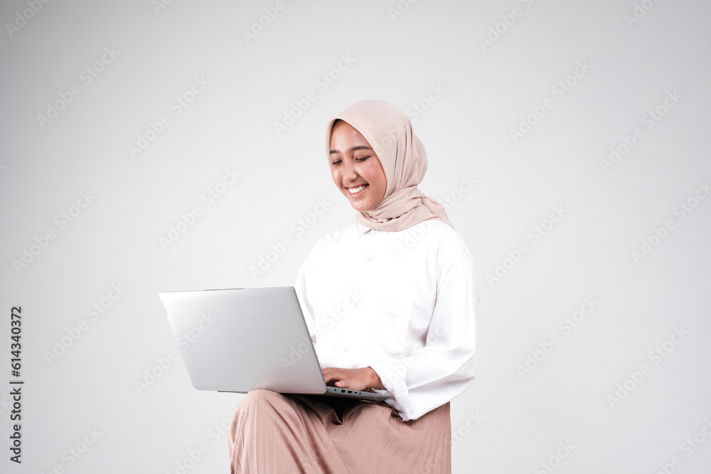 Muslimah doing her work with laptop isolated white background