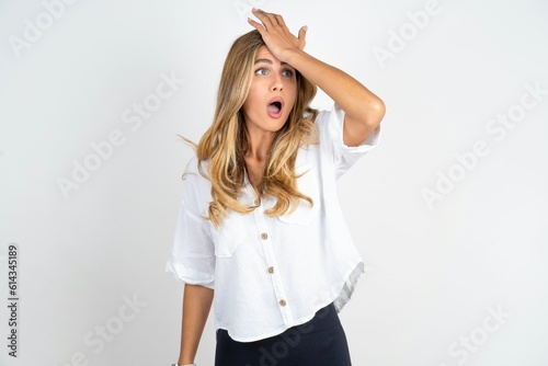 Young caucasian business woman wearing white shirt over white background surprised with hand on head for mistake, remember error. Forgot, bad memory concept.