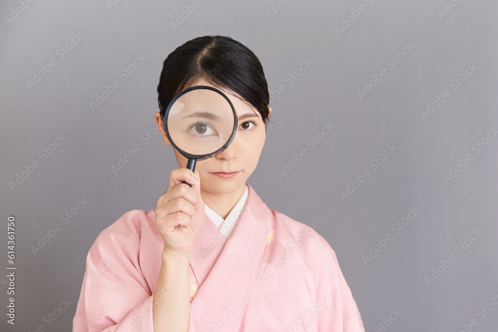 虫眼鏡を持つ着物を着た女性