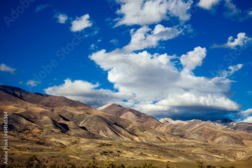 Majestic mountain landscape with dramatic blue sky and white clouds. Wild harsh nature of Altai.