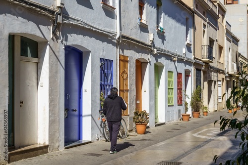 Man with his back turned walking through the streets of a Mediterranean village © Manuel Milan