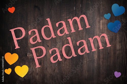 Pink Padam Padam with rainbow hearts on dark wooden board