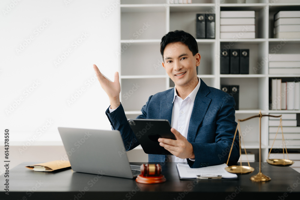 Attractive young lawyer in office Business man and lawyers discussing contract papers laptop and tablet with brass scale on desk in modern office. Law, legal services, advice,. Attractive young lawyer in office Business man and lawyers discussing contract papers laptop and tablet with brass scale on desk in modern office. Law, legal services, advice,.
