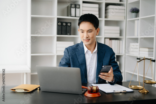 Attractive young lawyer in office Business man and lawyers discussing contract papers laptop and tablet with brass scale on desk in modern office. Law, legal services, advice,.