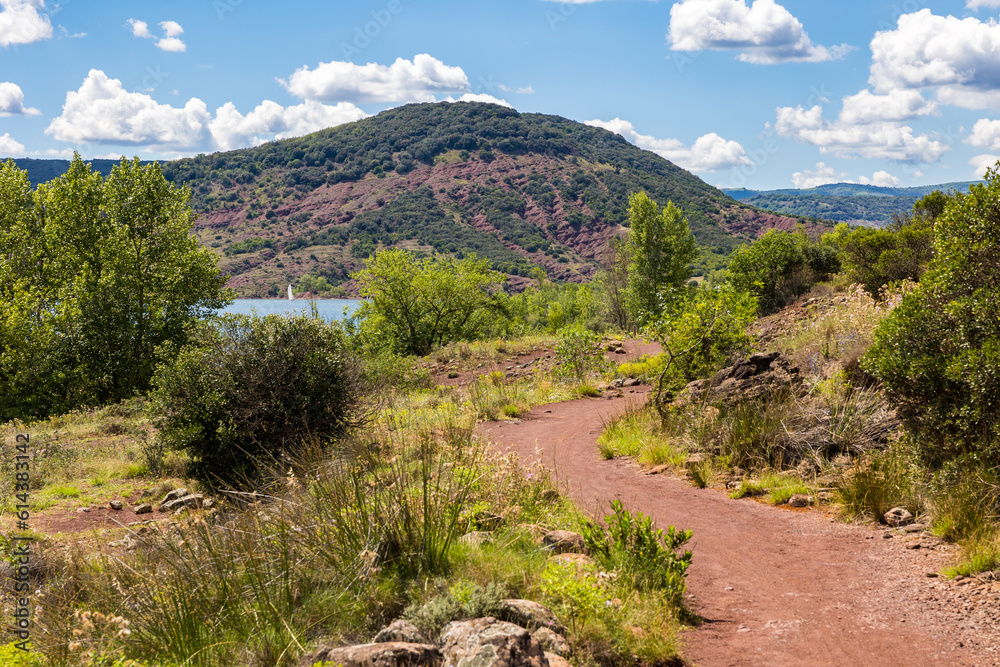 Petit voilier sur le Lac du Salagou depuis un chemin sur les berges Petit voilier sur le Lac du Salagou depuis un chemin sur les berges