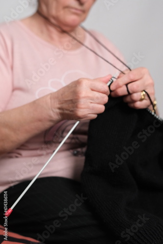 old woman spends time alone at home and knitting