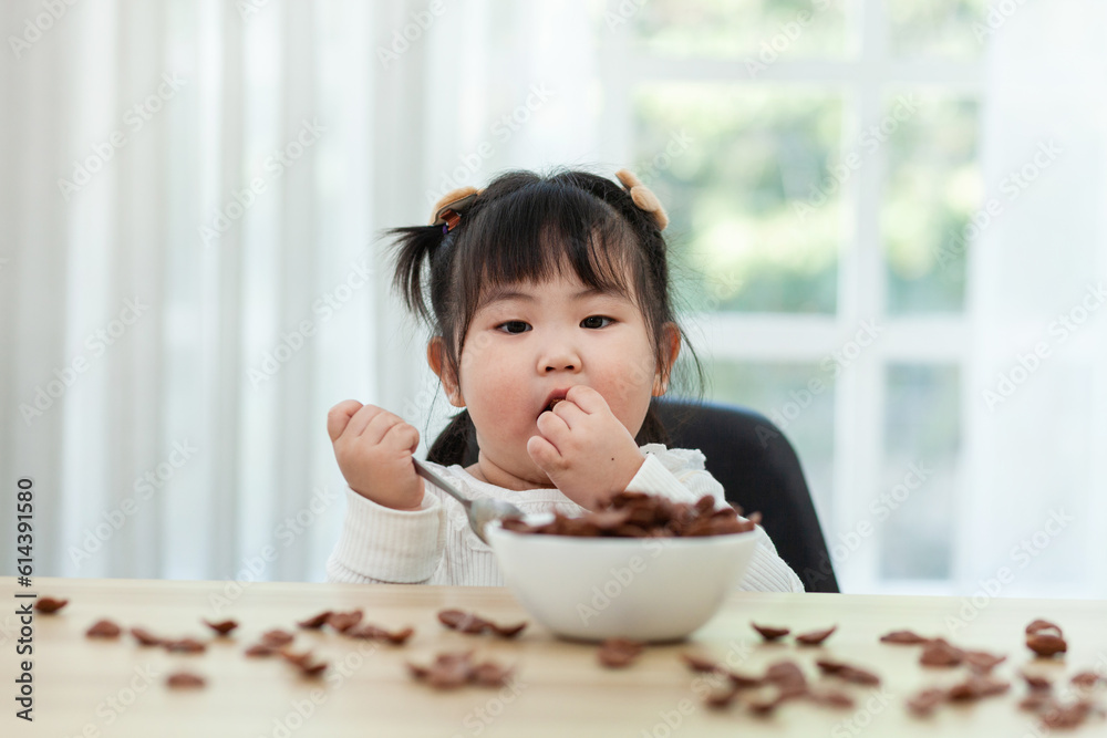 little girl wearing a white shirt Enjoy your breakfast on a brown wooden table. Have a happy meal. little girl wearing a white shirt Enjoy your breakfast on a brown wooden table. Have a happy meal.