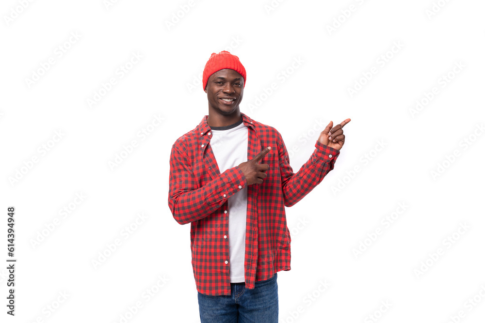 portrait of handsome 30s black american man dressed in red shirt and cap telling news with finger on white studio background with copy space portrait of handsome 30s black american man dressed in red shirt and cap telling news with finger on white studio background with copy space