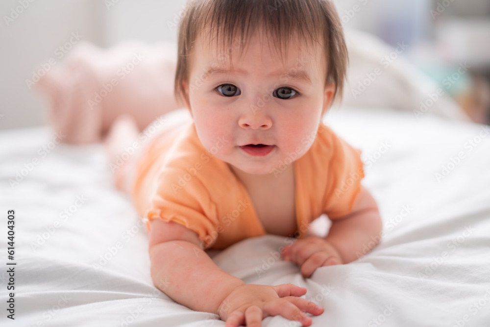 lifestyle home portrait of happy and beautiful 8 months old baby girl mixed race Asian Caucasian playing cheerful on bed exploring the surroundings curious lifestyle home portrait of happy and beautiful 8 months old baby girl mixed race Asian Caucasian playing cheerful on bed exploring the surroundings curious