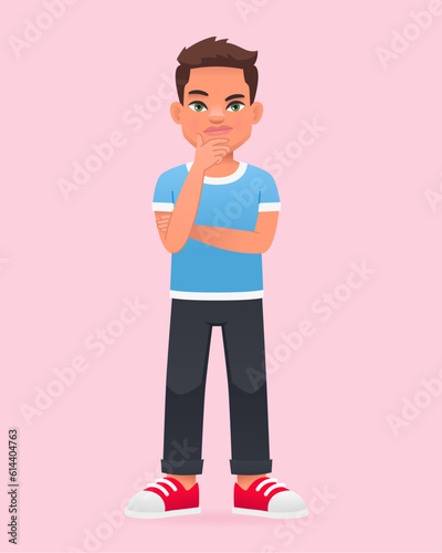 The little boy was thinking about something. A beautiful cute white schoolboy kid in a blue T-shirt.