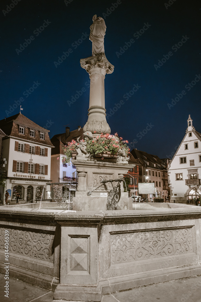 Obernai sous les étoiles : fontaine en pierre au cœur de la ville