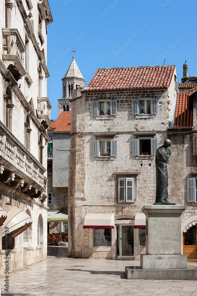A scene from the old town of Split and a view of the monument to Marko Marulic. Croatia.