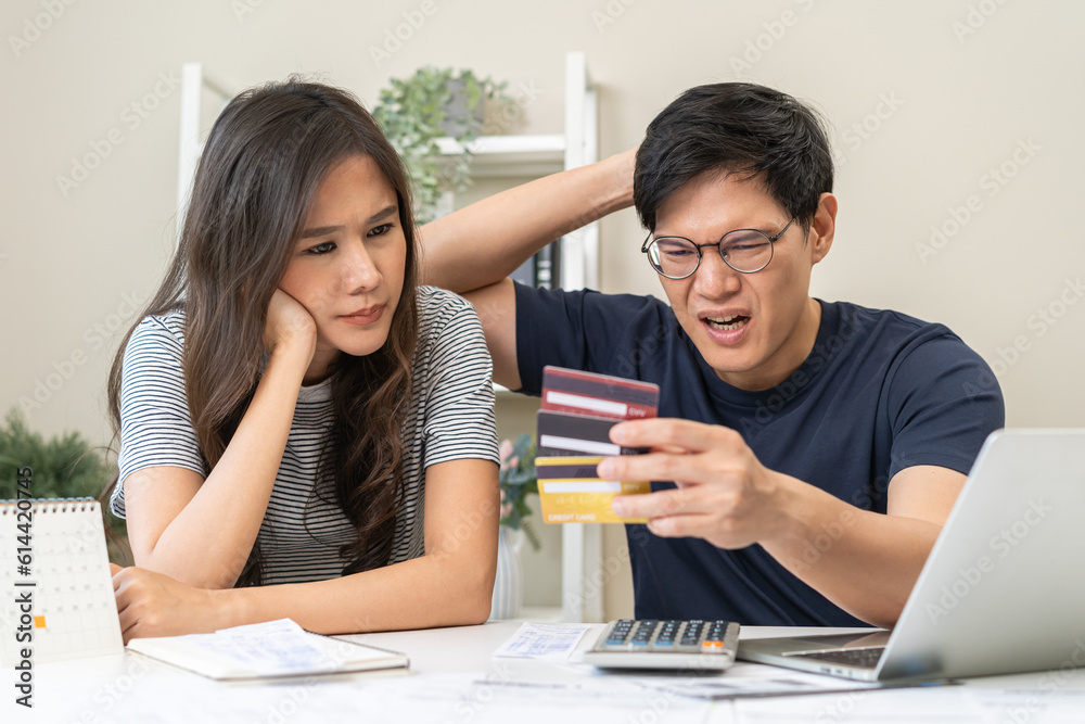 Stressed financial owe asian young couple love sitting stressed and confused hand calculate expense from credit card invoice, no money to pay, mortgage or loan. Debt, bankrupt or bankruptcy people. Stressed financial owe asian young couple love sitting stressed and confused hand calculate expense from credit card invoice, no money to pay, mortgage or loan. Debt, bankrupt or bankruptcy people.