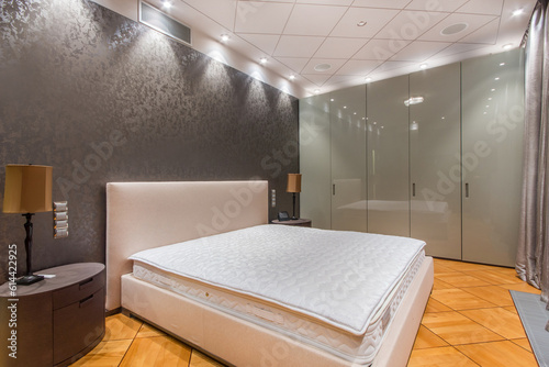 Bedroom interior with stylish design. Elegant furniture  parquet. Gray silkscreen on the wall.