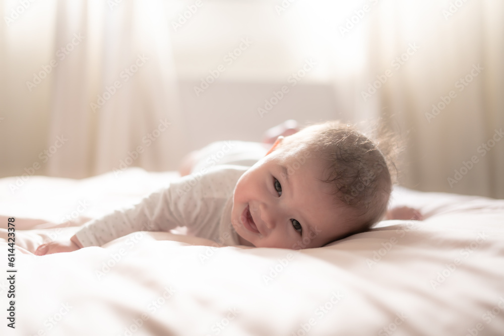 adorable and happy 5 months old baby girl gleefully discovers boundless joy while playfully exploring her bed. Surrounded by the warm glow of natural light the little on smiles cheerfully adorable and happy 5 months old baby girl gleefully discovers boundless joy while playfully exploring her bed. Surrounded by the warm glow of natural light the little on smiles cheerfully
