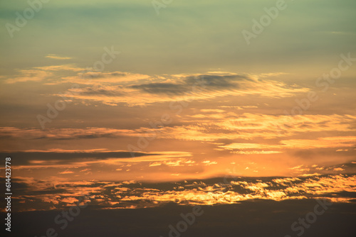 Row after row of neatly arranged white clouds. Beautiful orange-yellow sky at dusk. © twabian
