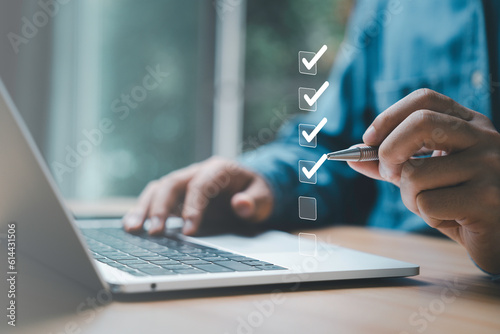 Businessman use pen to tick correct sign mark in checkbox for quality document control checklist and business approve project concept. © Dilok