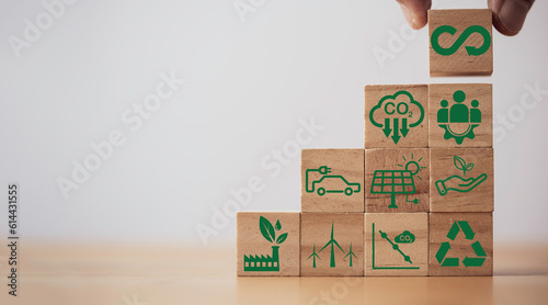 Hand holding Infinity symbol with Circular business economy environment icons on wooden cube for future sustainable investment growth and reduce environmental pollution for future concept.
