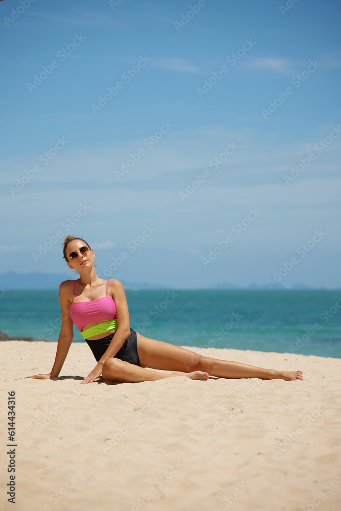 fashion outdoor photo of beautiful sexy woman with tided hair in elegant swimming suit relaxing on summer beach