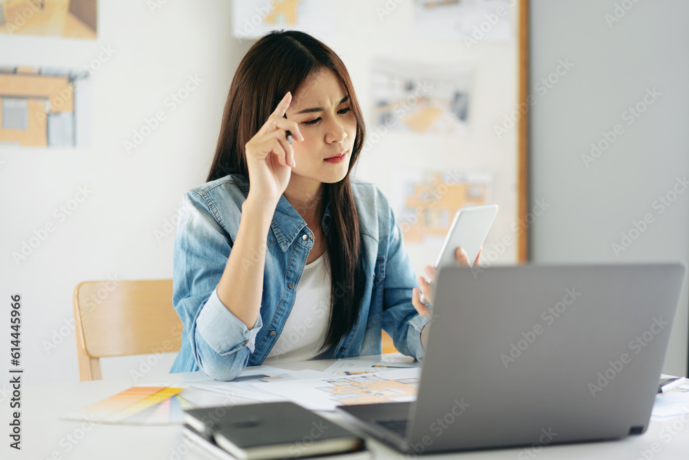 Woman architect using smartphone to reading data to sketching an Woman architect using smartphone to reading data to sketching an